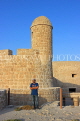 BAHRAIN, Manama, Karababad, Bahrain Fort (Qal'at al Bahrain), and man posing, BHR676JPL