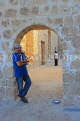 BAHRAIN, Manama, Karababad, Bahrain Fort (Qal'at al Bahrain), man posing by arch, BHR675JPL