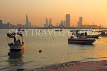 BAHRAIN, Muharraq, coastal fishing village area, boats, and Manama skyline, dusk, BHR2486JPL