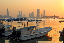 BAHRAIN, Muharraq, coastal fishing village area, boats, and Manama skyline, dusk, BHR2488JPL