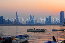 BAHRAIN, Muharraq, coastal fishing village area, boats, and Manama skyline, dusk, BHR2489JPL