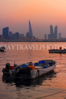 BAHRAIN, Muharraq, coastal fishing village area, boats, and Manama skyline, dusk, BHR2519JPL