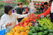 BAHRAIN, Noor El Ain, Garden Bazaar, Farmers Market, stalls, peppers, and shopper, BHR2027JPL