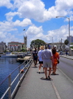 BARBADOS, Bridgetown, tourists on Chamberlain Bridge, government buildings, clocktower, BAR509JPL