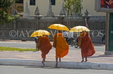 CAMBODIA, Phnom Penh, monks walking along road, CAM81JPL