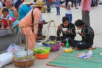 CAMBODIA, Phnom Penh, street food, people enjoying food bought from vendor, CAM2098JPL
