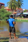 CAMBODIA, Siem Reap, town centre, Siem Reap River, man fishing, CAM2315JPL