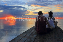 CAMBODIA, Tonle Sap Lake, tourist couple enjoying the sunset view from boat, CAM933JPL