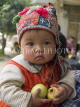 CHINA, Yunnan Province, Yuanyang, Hani hill tribe baby holding fruit, CH1540JPL