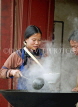 CHINA, Yunnan Province, Yuanyang market, woman cooking over steaming wok, CH1549JPL