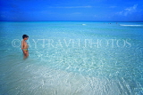 CUBA, Playa Larga, seascape, boy (tourist) paddling in shallow sea, CUB240JPL
