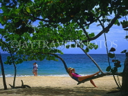DOMINICAN REPUBLIC, North Coast, Playa Dorada beach, tourist relaxing on tree branch, DR140JPL