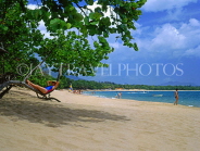 DOMINICAN REPUBLIC, North Coast, Playa Dorada beach, tourist relaxing on tree branch, DR337JPL