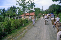 DOMINICAN REPUBLIC, countryside, tourists pony trekking through village, DR222JPL