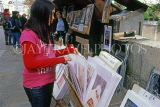 France, PARIS, Latin Quarter, stalls along River Seine, Quay de Montebello, girl browsing, FRA2189JPL