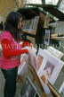 France, PARIS, Latin Quarter, stalls along River Seine, Quay de Montebello, girl browsing, FRA2190JPL