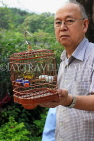 HONG KONG, Kowloon, Mong Kok, Yuen Po Street Bird Garden, man with songbird in cage, HK935JPL