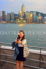 HONG KONG, Kowloon, Tsim Sha Tsui Promenade, gilr taking selfie against HK skyline, HK1264JPL