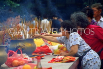 HONG KONG, Kowloon, Wong Tai Sin Temple, worshipper with incense sticks, HK489JPL