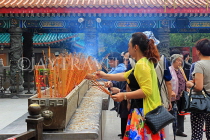 HONG KONG, Kowloon, Wong Tai Sin Temple, worshippers with incense sticks, HK1169JPL