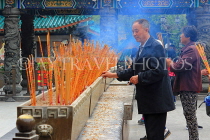 HONG KONG, Kowloon, Wong Tai Sin Temple, worshippers with incense sticks, HK1170JPL
