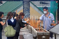 HONG KONG, Kowloon, Wong Tai Sin Temple, worshippers with incense sticks, HK1175JPL