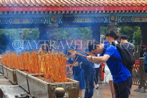 HONG KONG, Kowloon, Wong Tai Sin Temple, worshippers with incense sticks, HK1179JPL