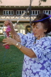 Hawaiian Islands, OAHU, lady demonstrating Lei making with fresh Orchids, HAW361JPL