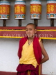 INDIA, Sikkim, Phodong Monastery, monk standing next to prayer wheels, IND1347JPL
