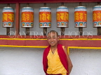 INDIA, Sikkim, Phodong Monastery, monk standing next to prayer wheels, IND1348JPL