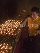INDIA, Sikkim, monk lighting butter candles at a Tibetan monastery, IND1483JPL