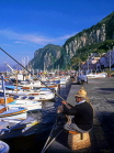 ITALY, Campania, Amalfi Coast, CAPRI, fishing boats along Marina Grande, man fishing, ITL959JPLA