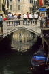 Italy, VENICE, people seated on bridge over small canal, ITL232JPL