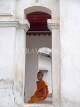 LAOS, Luang Prabang, monk sitting in archway of temple, LAO55JPL
