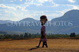 MADAGASCAR, Ambalavao, woman walking with a basket on the head, MDG209JPL