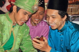MALAYSIA, Kuala Lumpur, cultural dancers with moble phone, MSA726JPL