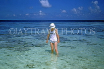 MALDIVE ISLANDS, Coral reef, exposed coral at low tide and tourist paddling, MAL684JPL