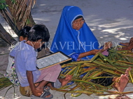 MALDIVE ISLANDS, Maafushi, local fishing island village, child with teacher, reading Arabic, MAL546JPL