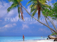 MALDIVE ISLANDS, beach scene with leaning coconut trees, tourist paddling, MAL732JPL