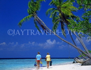 MALDIVE ISLANDS, couple along beach, leaning coconut trees, MAL021JPL