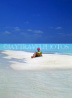 MALDIVE ISLANDS, holidaymaker sunbathing on patch of sand, shallow water, MAL255JPL