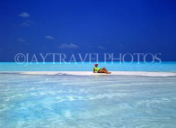 MALDIVE ISLANDS, holidaymaker sunbathing on strip of sand, shallow water, MAL253JPL