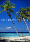 MALDIVE ISLANDS, leaning coconut trees and tourist walking along beach, MAL736JPL