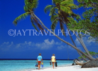 MALDIVE ISLANDS, typical island, couple along beach, leaning coconut trees, MAL733JPL