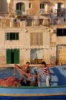 MALTA, St Julian's, two fishermen in boat, sorting out nets, MLT744JPL