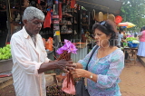 SRI LANKA, Anuradhapura, pilgrim buying flowers to make offerings, SLK5620JPL
