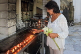 SRI LANKA, Colombo, Gangaramaya temple, worshipper placing oil lamps, SLK5468JPL
