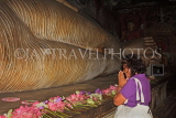 SRI LANKA, Dambulla Cave Temple (Golden Temple), Buddha statue in cave, and worshipper, SLK2890JPL