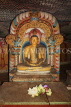 SRI LANKA, Dambulla Cave Temple (Golden Temple), Buddha statue in cave and flower offerings, SLK2775JPL