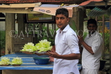 SRI LANKA, Kandy, Temple of the Tooth (Dalada Maligawa), man selling flowers for offerings, SLK3423JPL